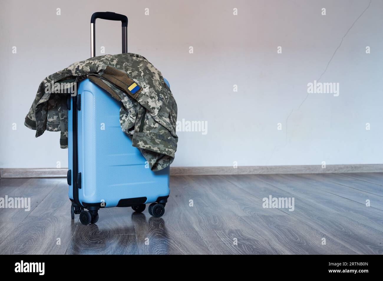 Borsa da viaggio con manico aperto e giacca uniforme militare ucraina. Viaggi, esercito, mobilitazione Foto Stock