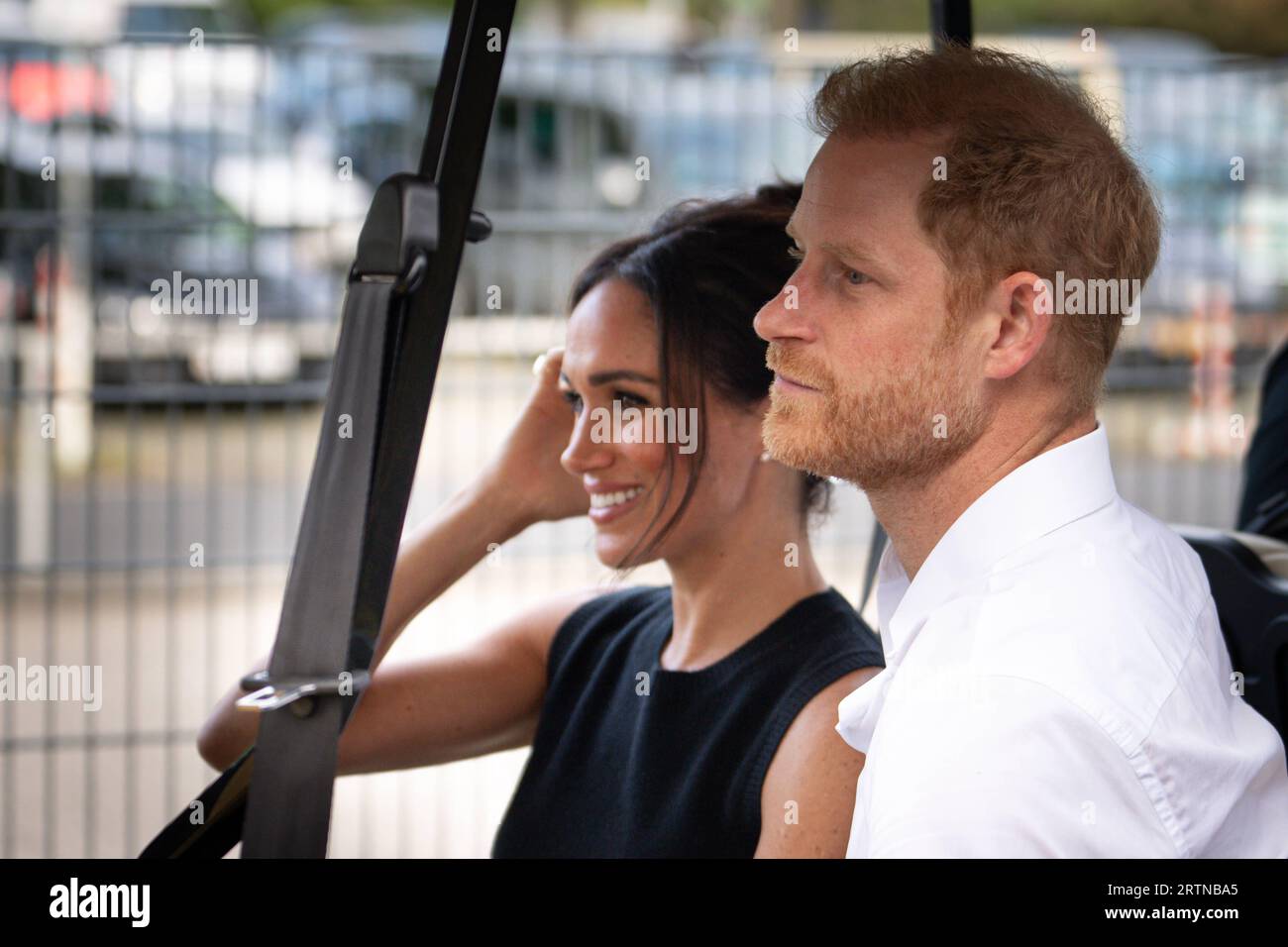 Invictus Games 2023 a Duesseldorf Prinz Harry, Duca di Sussex gemeinsam mit Ehefrau Meghan Markle, Duchessa di Sussex gut gelaunt im Buggy auf dem Weg zur Schwimmhalle fuer die Schwimmwettkaempfe bei den Invictus Games 2023 a Duesseldorf, Duesseldorf, 13.09.2023 Duesseldorf Nordrhein-Westfalen Deutschland Games 2023 duca di Sussex insieme alla moglie Meghan Markle, duchessa di Sussex di buon umore nel buggy sulla strada per la piscina per le competizioni di nuoto agli Invictus Games 2023 a Duesseldorf, Duesseldorf, 13 09 2023 Duesseldorf Nor Foto Stock