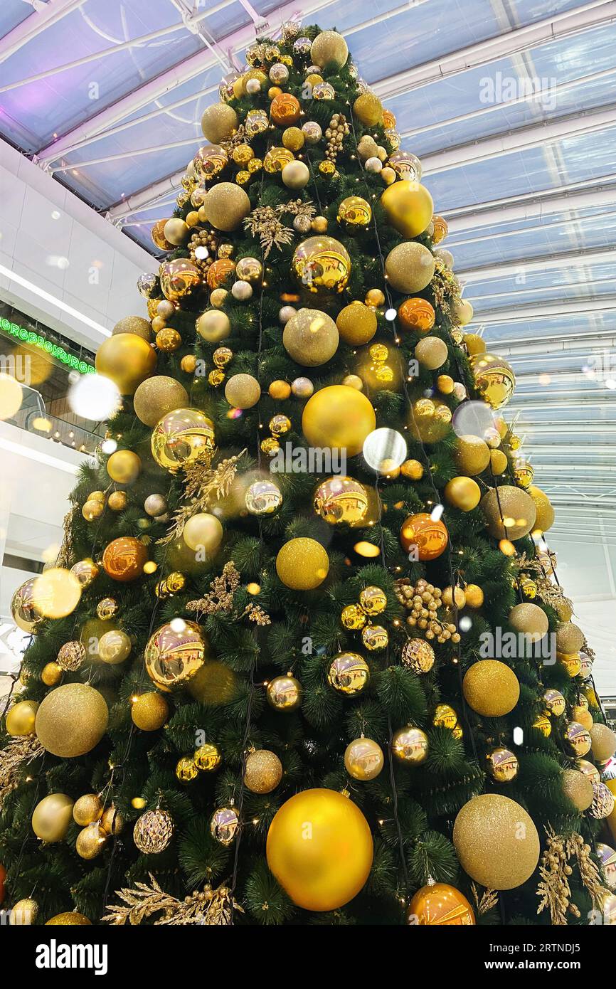 Albero di Natale nel centro commerciale europeo. Anno nuovo. Vacanze invernali. Decorazione di Natale dorata. Foto Stock