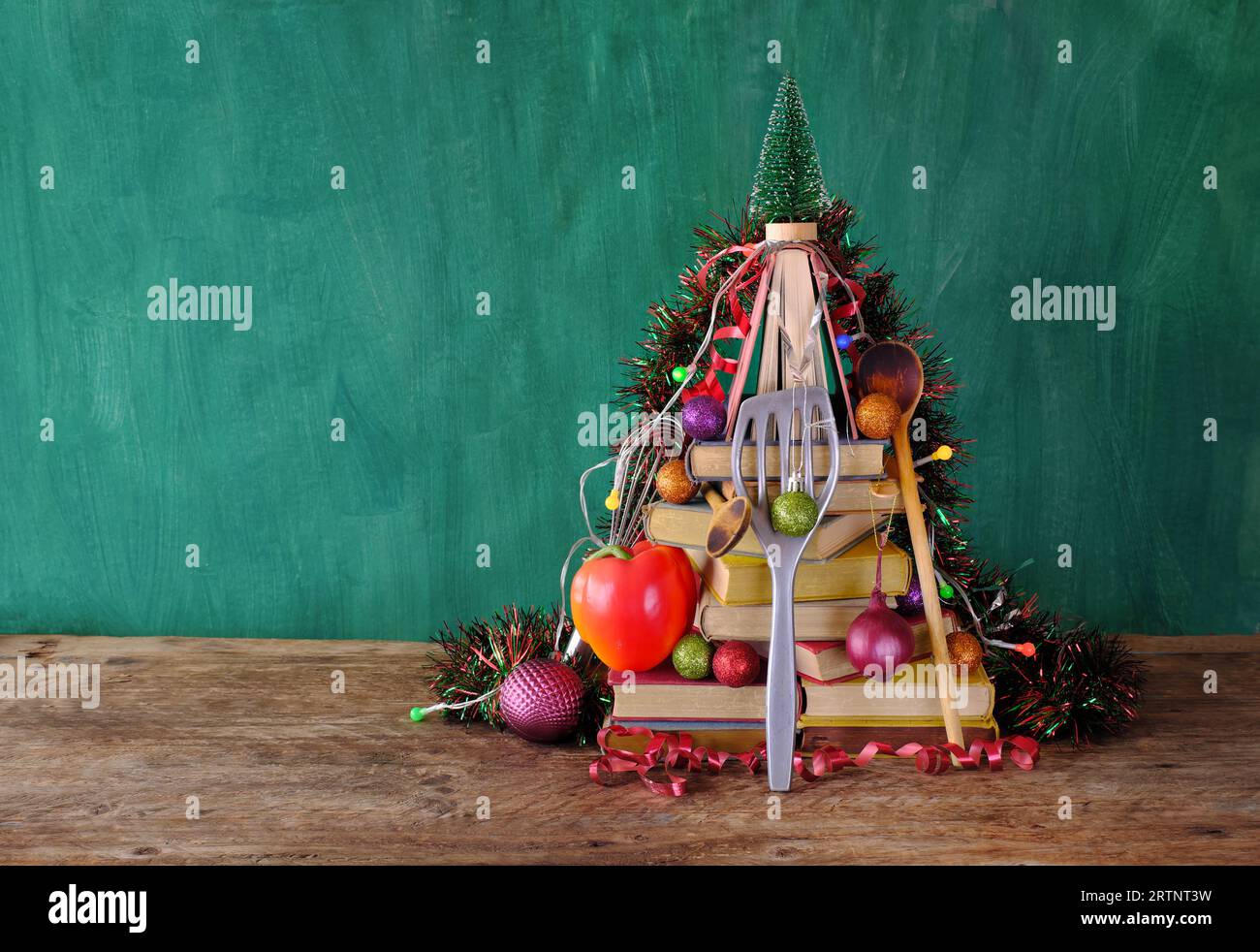 Libri di cucina come regalo di natale, cucina, cucina, cibo, lettura, letteratura, natale, concetto natalizio. Decorazioni festive con libri di cucina, peperoni e Foto Stock