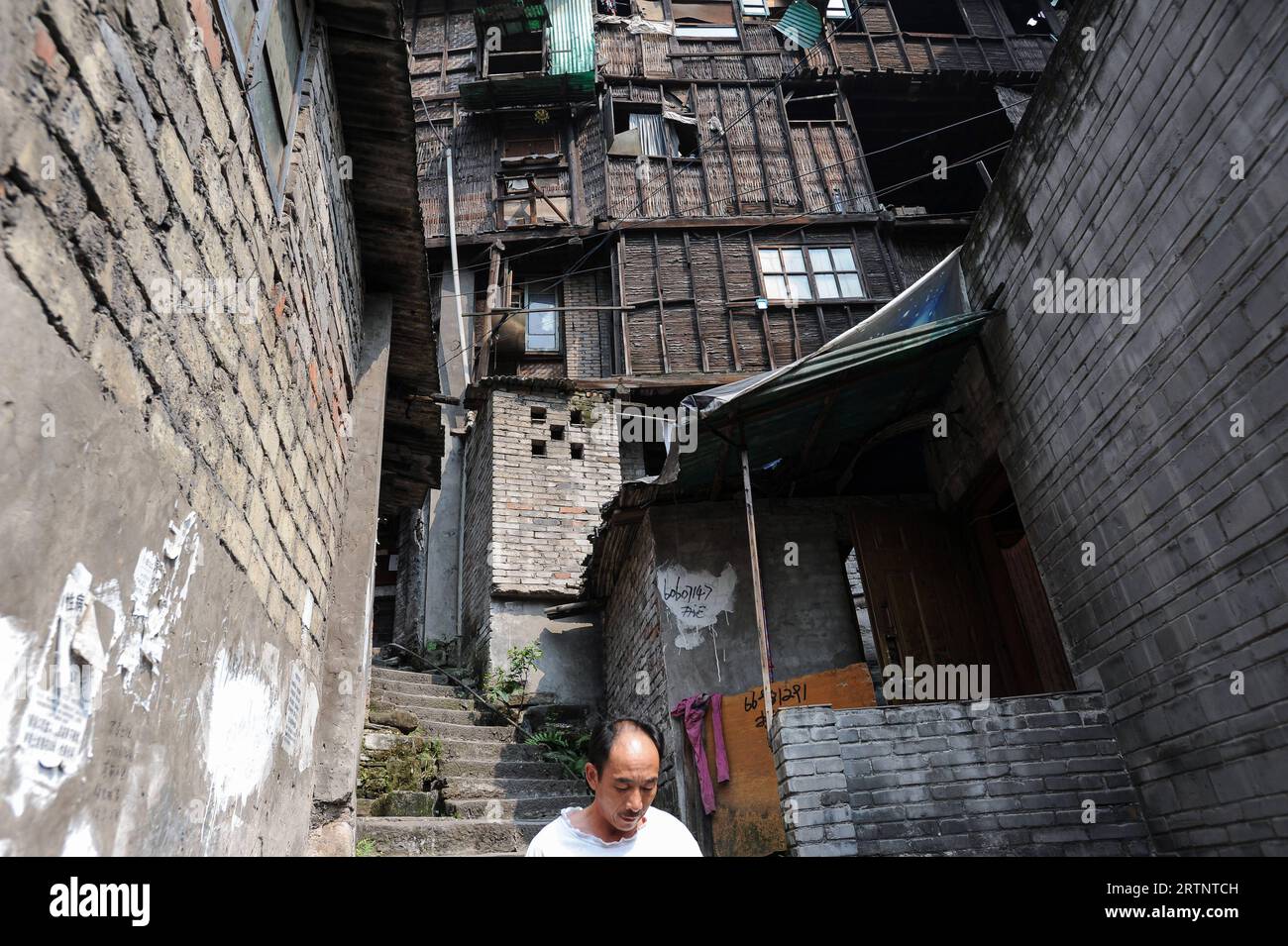 04.08.2012, Chongqing, Cina, Asien - Ein Mann im Gebiet der Eighteen Stairs mit traditionellen Haeusern in der Altstadt des Shibati-Gebiets im Stadtbezirks Yuzhong. Die Regierung Hat damit begonnen, viele traditionelle alte Haeuser im Shibati-Gebiet abzureissen und es in einen Ort zu verwandeln, der Touristen anzieht. Die chinesische megacity Chongqing liegt am Zusammenfluss zweier Hauptwasserstrassen, dem Jangtse und dem Jialing Fluss und ist eine der schnellstwachsenden Metropolen weltweit. Chongqing ist auch einer der fuenf Stadtstaaten Chinas, wobei die Stadt Chongqing die am dichtesten b Foto Stock