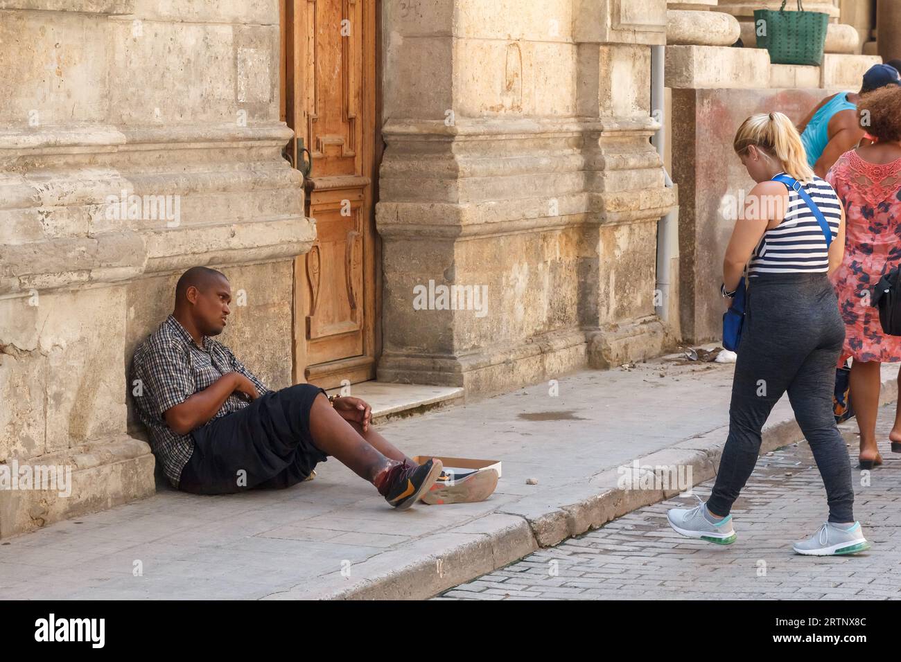 L'Avana, Cuba - 30 agosto 2023: Un giovane cubano che implorava in un marciapiede della città Foto Stock