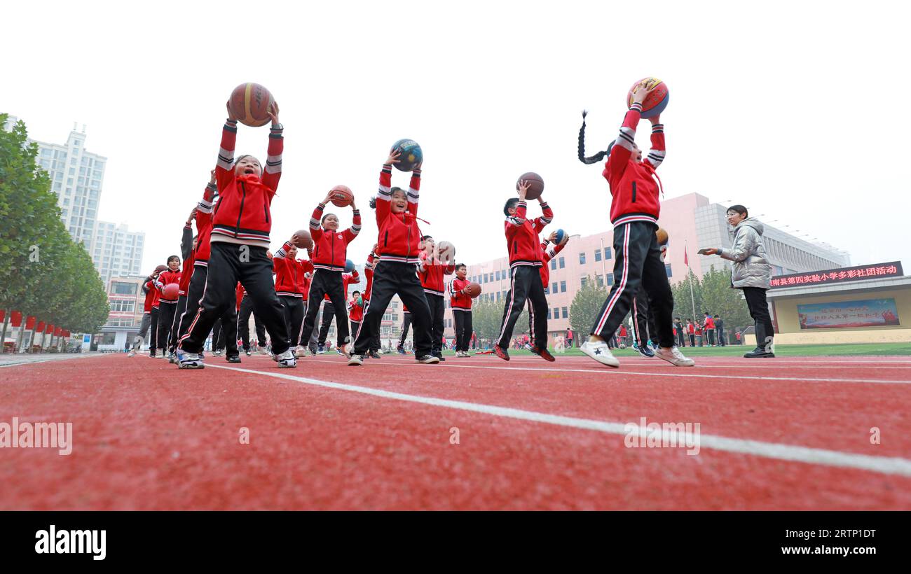 LUANNAN COUNTY, Cina - 3 novembre 2021: Gli studenti delle scuole primarie stanno addestrando le abilità di base di basket in classe, Cina settentrionale Foto Stock