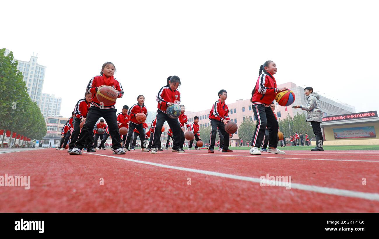 LUANNAN COUNTY, Cina - 3 novembre 2021: Gli studenti delle scuole primarie stanno addestrando le abilità di base di basket in classe, Cina settentrionale Foto Stock