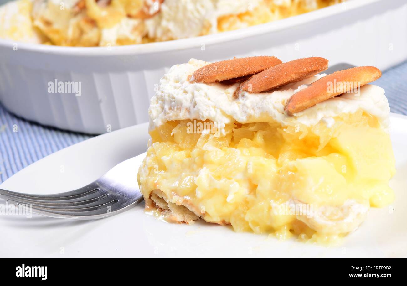 Torta di budino con wafer alla vaniglia servita con ananas e panna montata Foto Stock