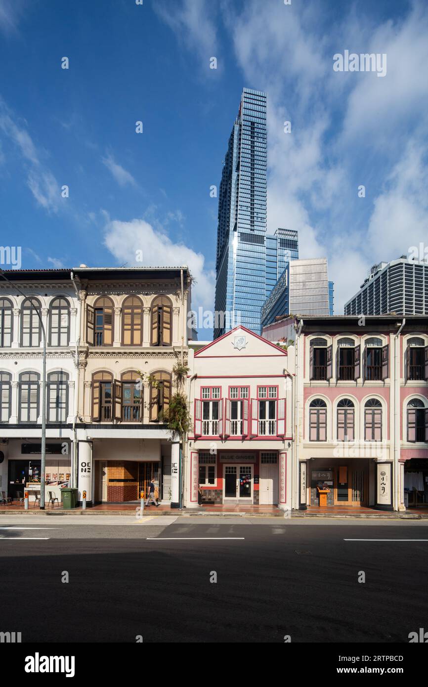 vista verticale dei negozi lungo la strada. Sullo sfondo si trova il grattacielo più alto di Singapore, Guoco Tower. Foto Stock