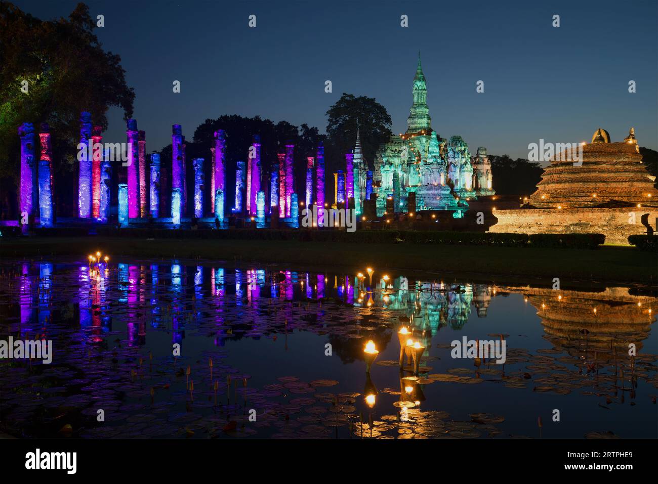 Le rovine del tempio buddista Wat Mahathat, con luci festive in tarda serata. La festa della luce in onore del 25° anniversario della Foto Stock
