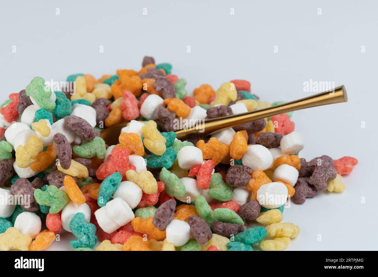 Cucchiaio all'interno del colorato fiocco di mais su sfondo bianco studio vista ravvicinata Foto Stock