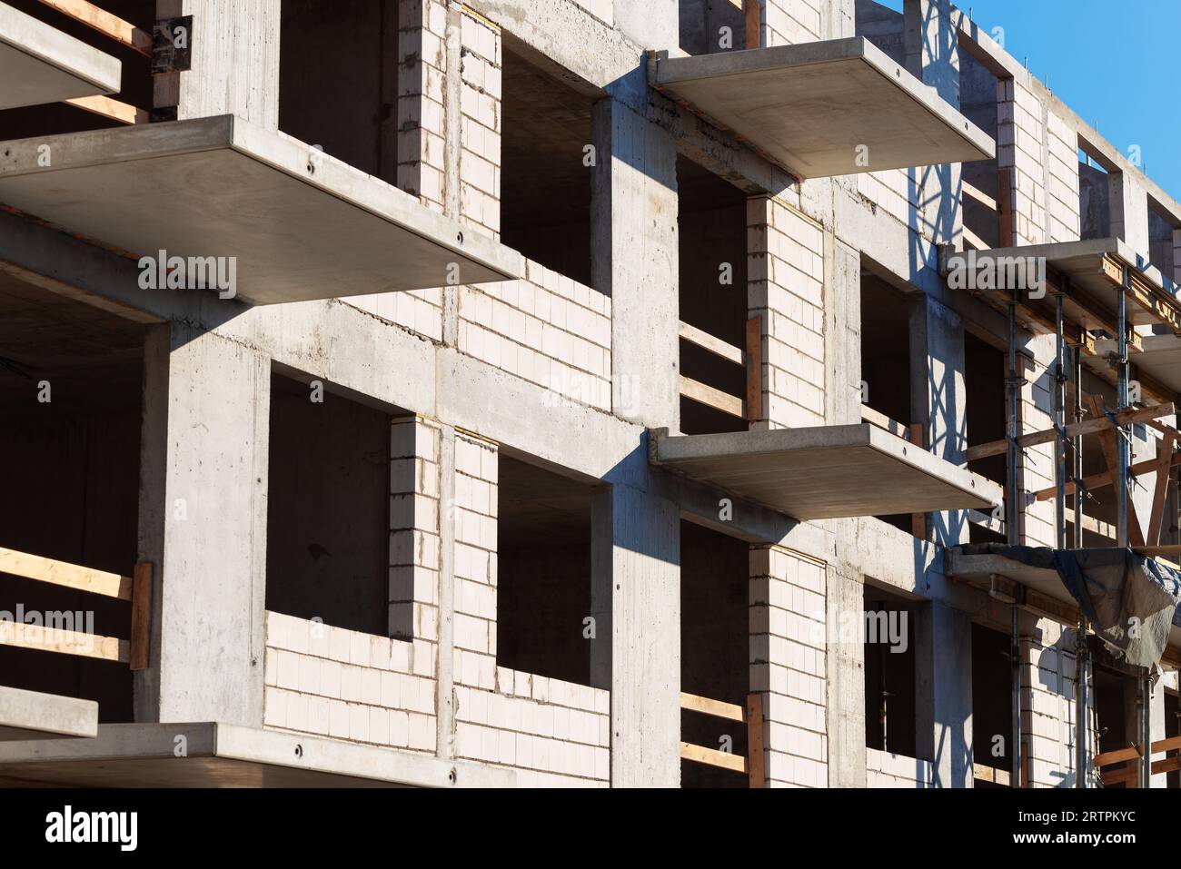 Struttura a conchiglia di edifici con pareti in mattoni, mandrino in cemento armato e balcone da vicino Foto Stock