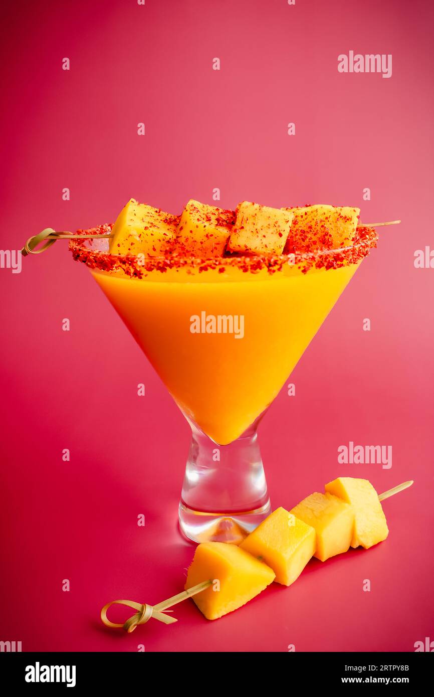 Margarita mango con torsione di peperoncino curcuma e guarnigione di mango: Cocktail mescolato con margarita curcuma mango con un bordo condito con peperoncino-lime Foto Stock Margarita mango con torsione di peperoncino curcuma e guarnigione di mango: Cocktail mescolato con margarita curcuma mango con un bordo condito con peperoncino-lime Foto Stock