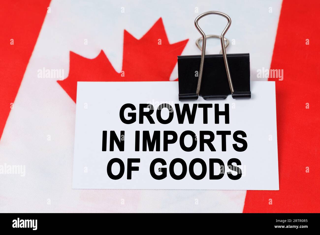 Economia e finanza. Sulla bandiera del Canada si trova un biglietto da visita con l'iscrizione - crescita delle importazioni di beni. Foto Stock
