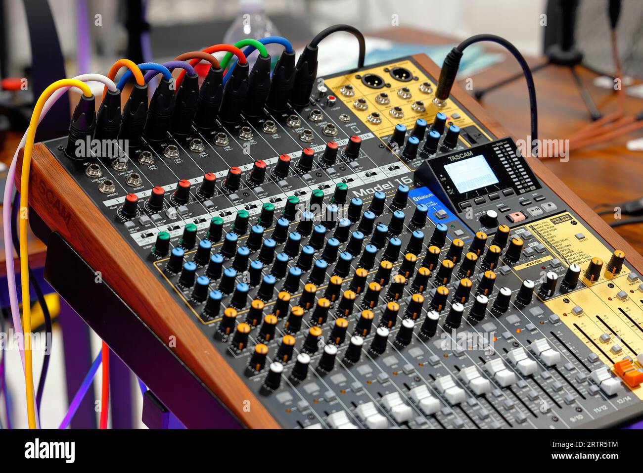 Un'interfaccia mixer Tascam Model 16 studio e un dispositivo di registrazione multitrack con ingressi microfono XLR colorati collegati. Foto Stock