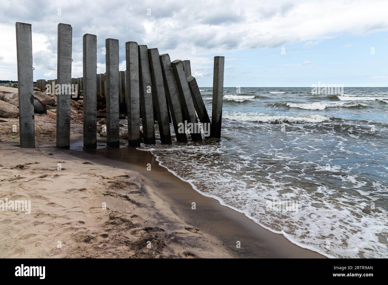Paesaggio costiero con pilastri di cemento, frangiflutti rotti montati sulla costa del Mar Baltico. Svetlogorsk, Oblast' di Kaliningrad, Russia Foto Stock