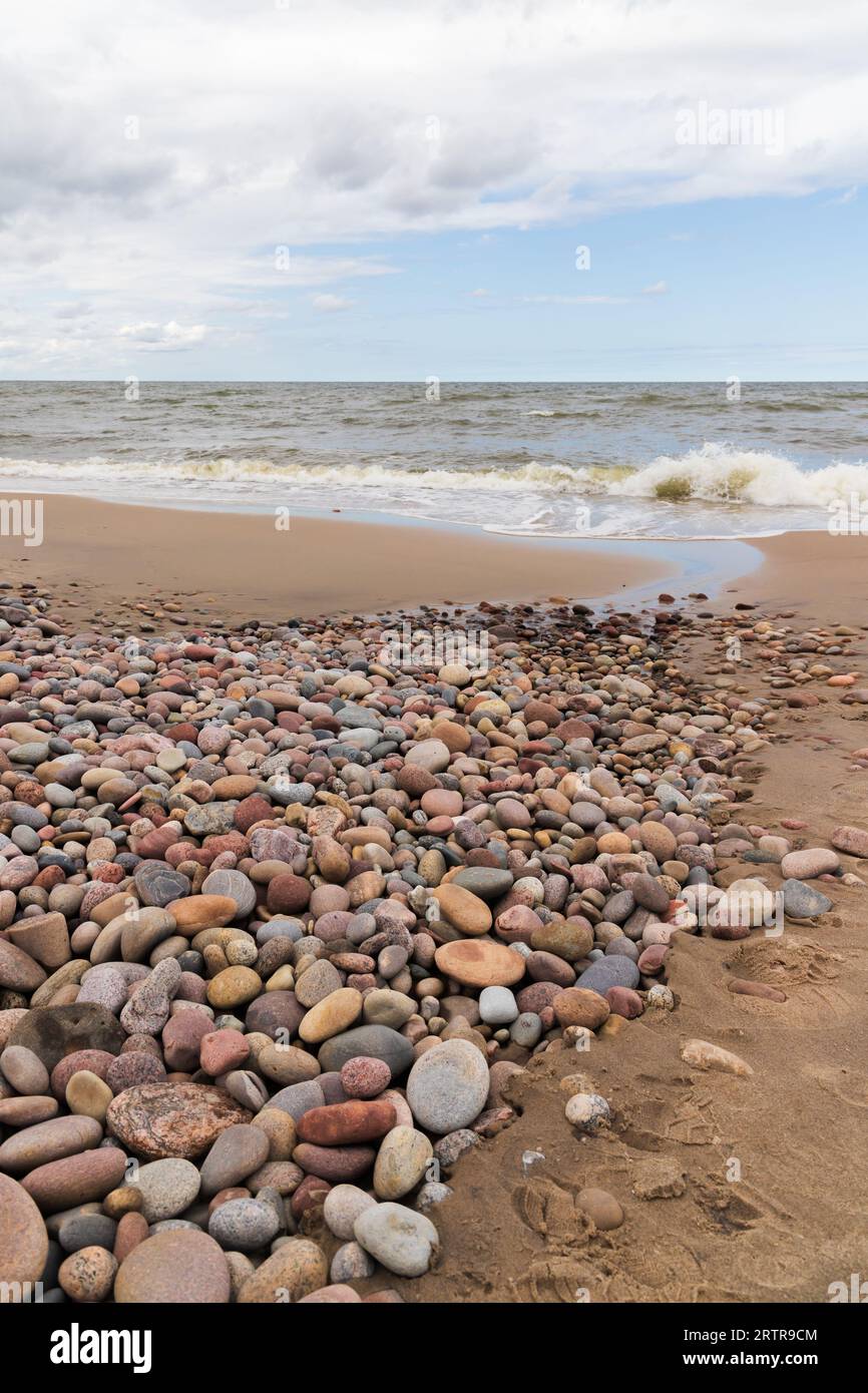 Paesaggio costiero con acqua costiera e ciottoli colorati. Costa del Mar Baltico. Zelenogradsk, regione di Kaliningrad, Russia. Foto verticale Foto Stock