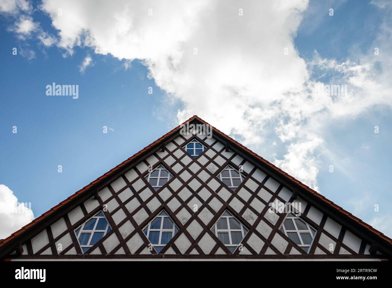 Frammento esterno di una vecchia casa tedesca, con finestre sotto il cielo blu nuvoloso. Svetlogorsk, Oblast' di Kaliningrad, Russia Foto Stock