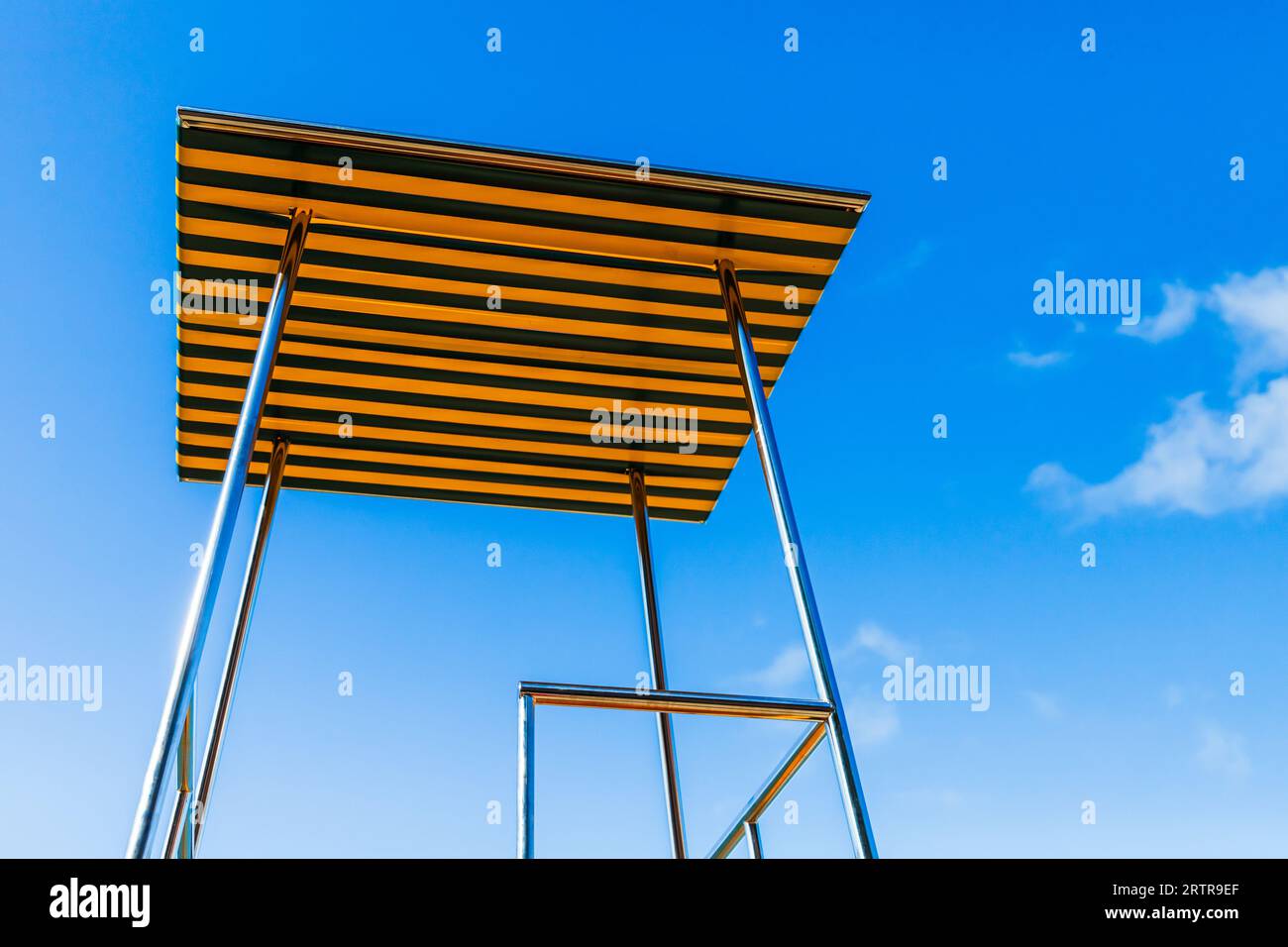 Una torre di salvataggio vuota montata sulla spiaggia è sotto il cielo blu Foto Stock