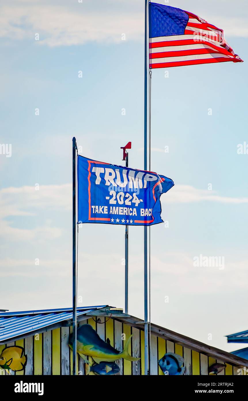 Una bandiera di Trump 2024 vola accanto a una bandiera americana in un molo di Coden Beach, 11 settembre 2023, a Coden, Alabama. Foto Stock