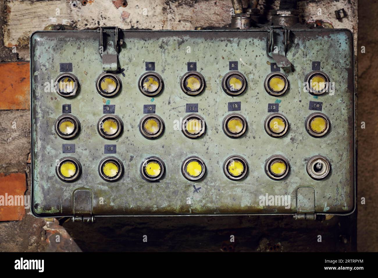 Vecchia scatola elettrica sporca con pulsanti in una vecchia fabbrica abbandonata Foto Stock