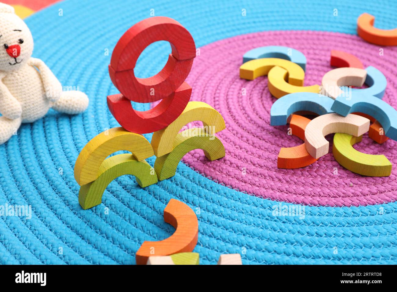 Coloratissimi pezzi di legno su tappetino colorato. Giocattolo educativo per lo sviluppo di abilità motorie Foto Stock