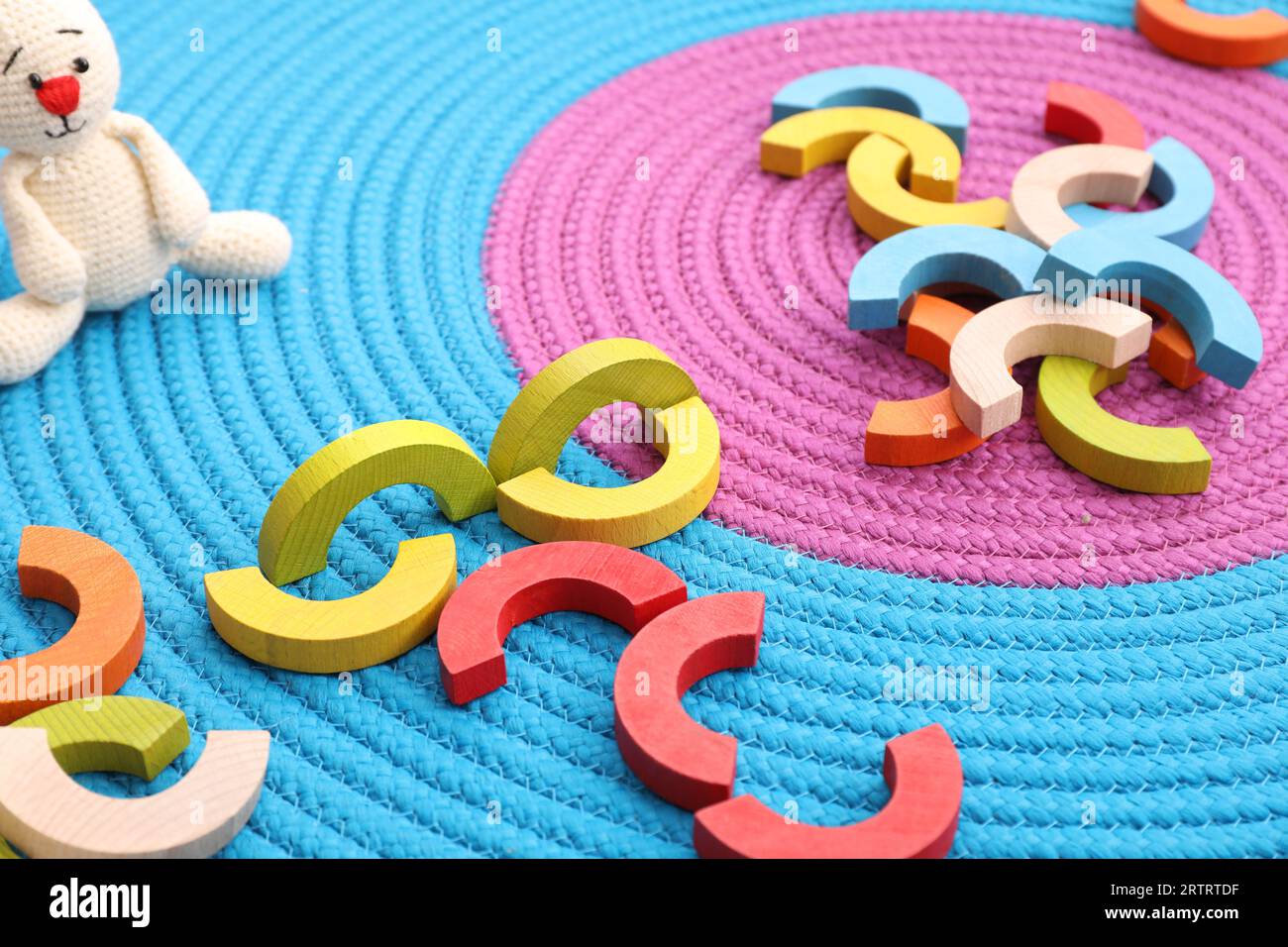 Coloratissimi pezzi di legno su tappetino colorato. Giocattolo educativo per lo sviluppo di abilità motorie Foto Stock