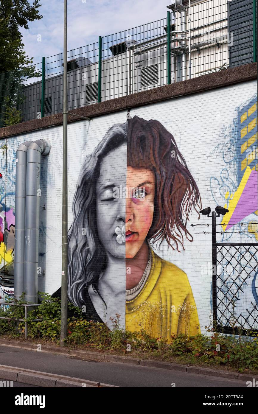 Volto di una ragazza, metà a colori, una in bianco e nero, murale socialmente critico dell'artista di strada Oreo, Universitaesstrasse, Bochum, North Foto Stock