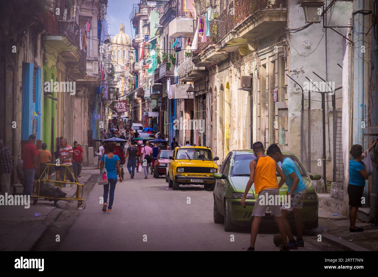 L'Avana, Cuba su dicembre 22, 2015: il popolo cubano camminando in una strada vecchia Havana con il Capitolio edificio governativo in background Foto Stock
