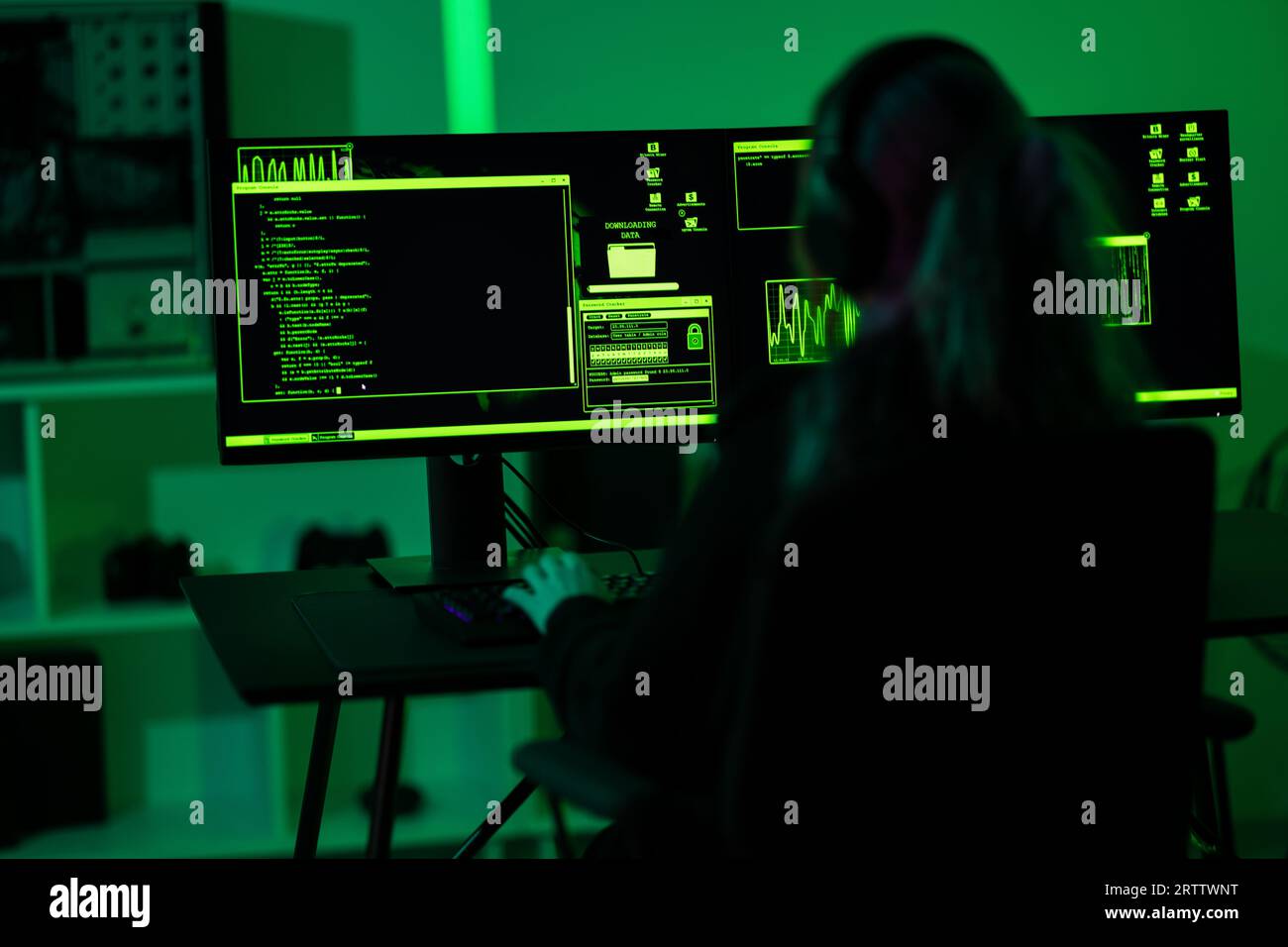 Gli hacker informatici codificano malware per sfruttare la vulnerabilità di un programma o di un sistema su un computer in una stanza buia Foto Stock