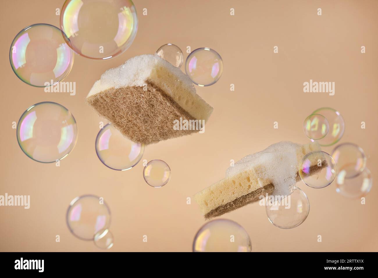 Spugna naturale per lavastoviglie con bolle di sapone su sfondo beige. Oggetti per lavori di casa ecocompatibili. Foto Stock