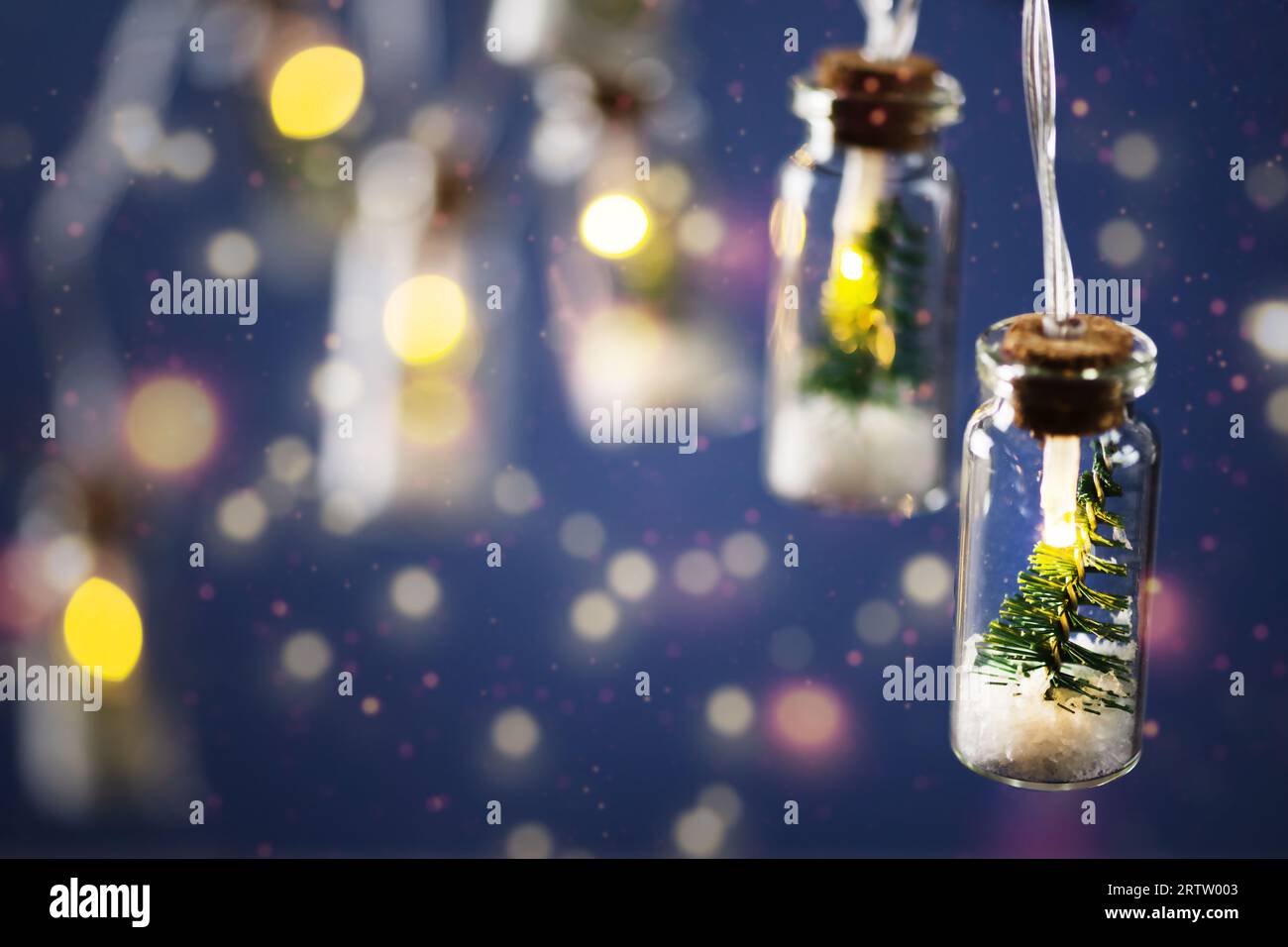 Creative luci di ghirlanda natalizia con bokeh. Albero di Natale in un vaso di vetro con neve. Biglietto d'auguri di Natale. Foto Stock