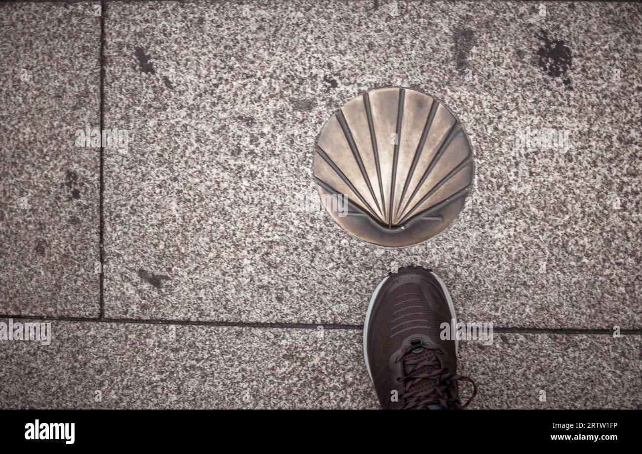 Lugo, Spagna, 6 settembre 2023: Direttamente sopra la scarpa da trekking e la conchiglia di San Giacomo di camino Santiago de Compostela Foto Stock