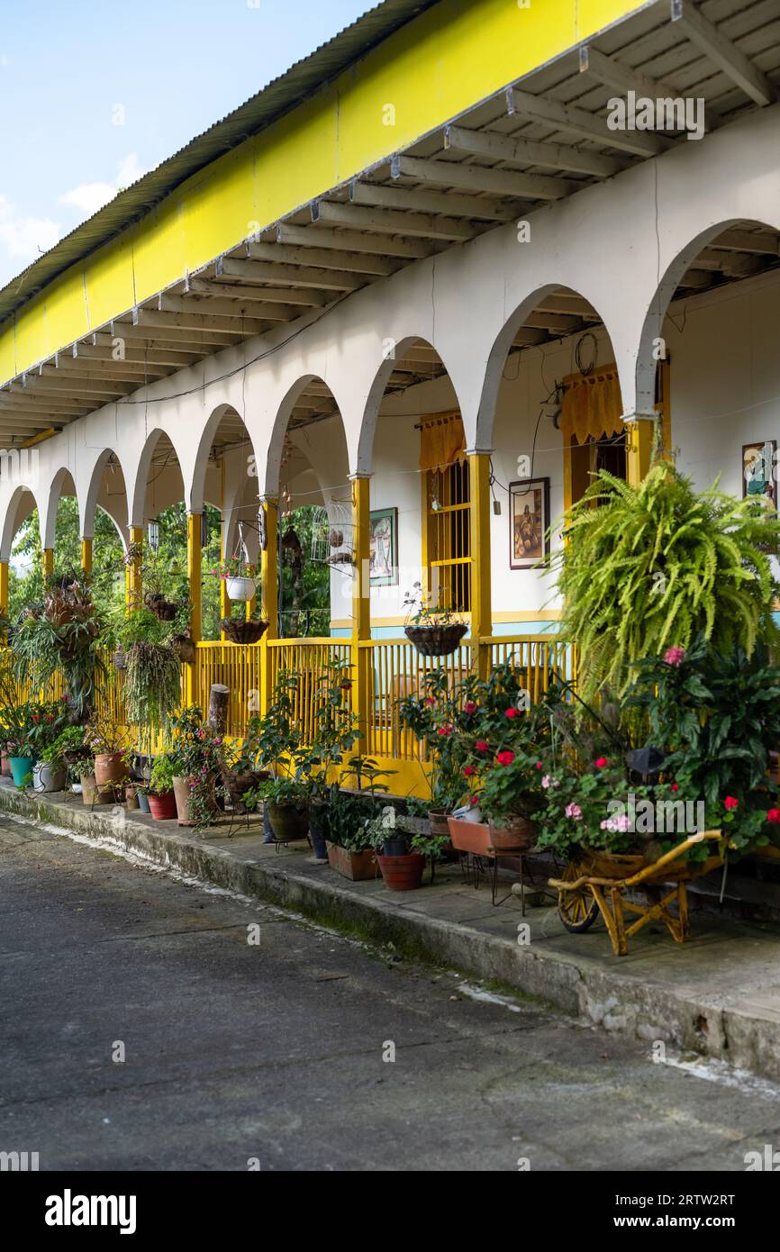 9 luglio 2023: Esterno vivido della tradizionale fattoria colombiana con vasi appesi di fronte al portico di Pijao, Colombia Foto Stock