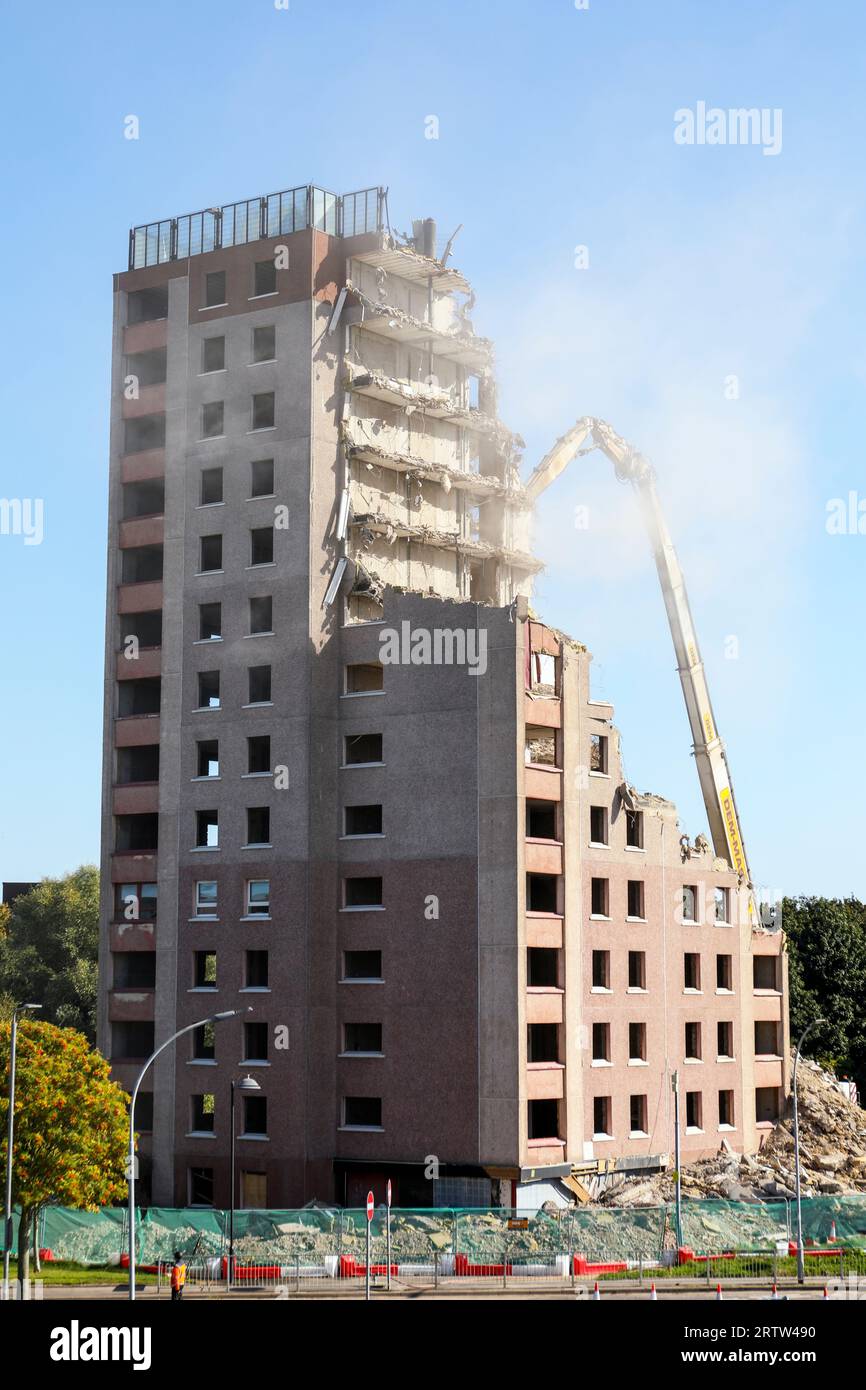 Alto blocco di appartamenti, Irvine, Ayrshire, Scozia, Regno Unito, essere demolito da una gru meccanica. Foto Stock