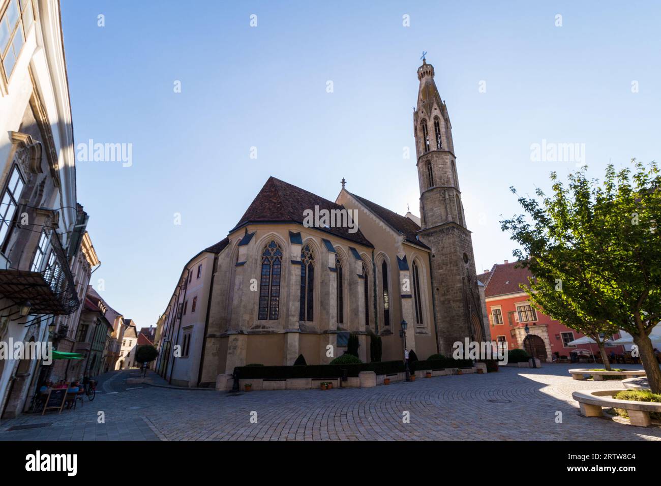 FO ter (piazza principale) con la chiesa benedettina (XIV secolo) retroilluminata, Sopron, Ungheria Foto Stock