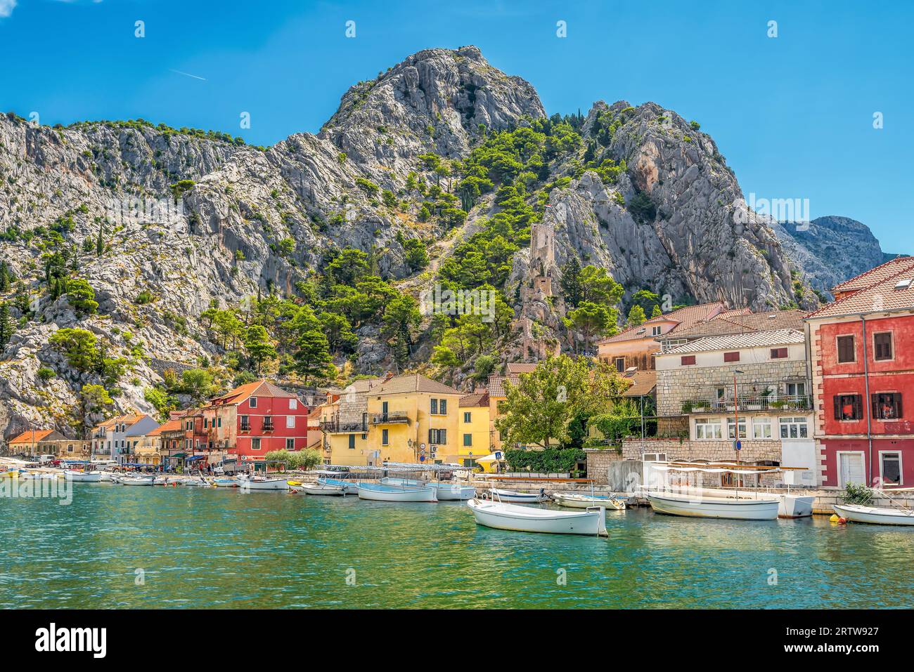 Vista panoramica della città vecchia di Omis in Croazia con il mare Adriatico e le montagne con alberi di pino sullo sfondo Foto Stock