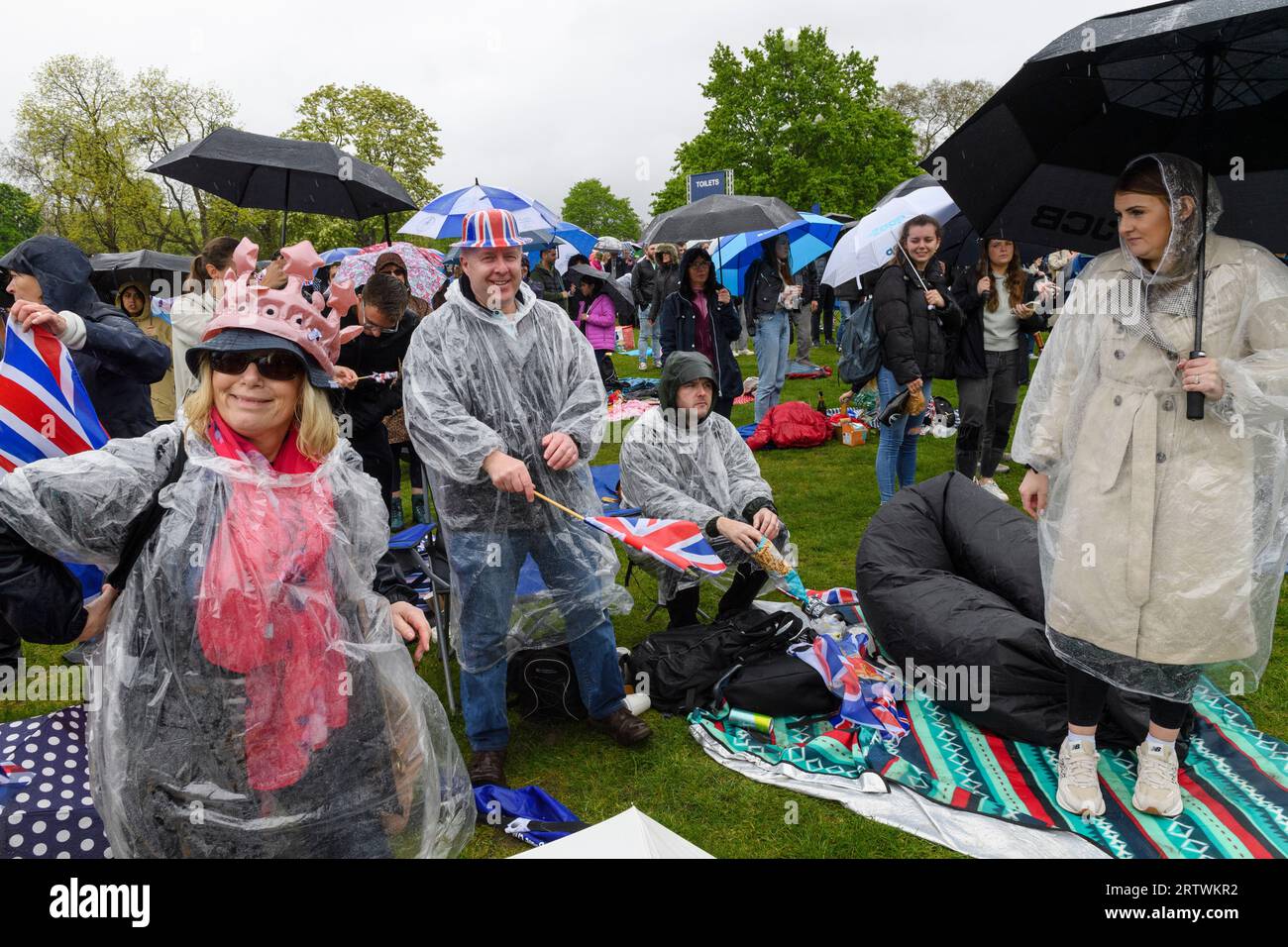 Una grande folla che sfiora la pioggia per guardare l'incoronazione di re Carlo III, su un gigantesco schermo TV. Hyde Park, Londra, Regno Unito. 6 maggio 2023 Foto Stock