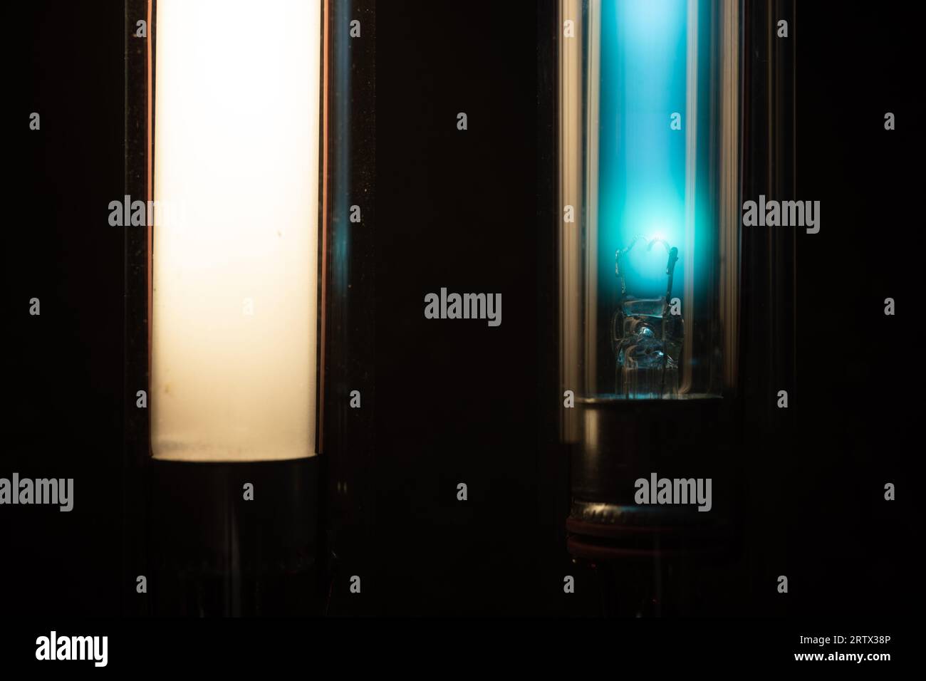 Illuminazione lineare a tubo o striscia, sinistra un tubo fluorescente rivestito ai fosfori, destra una lampada della stessa struttura ma chiara, che consente la visione interna Foto Stock