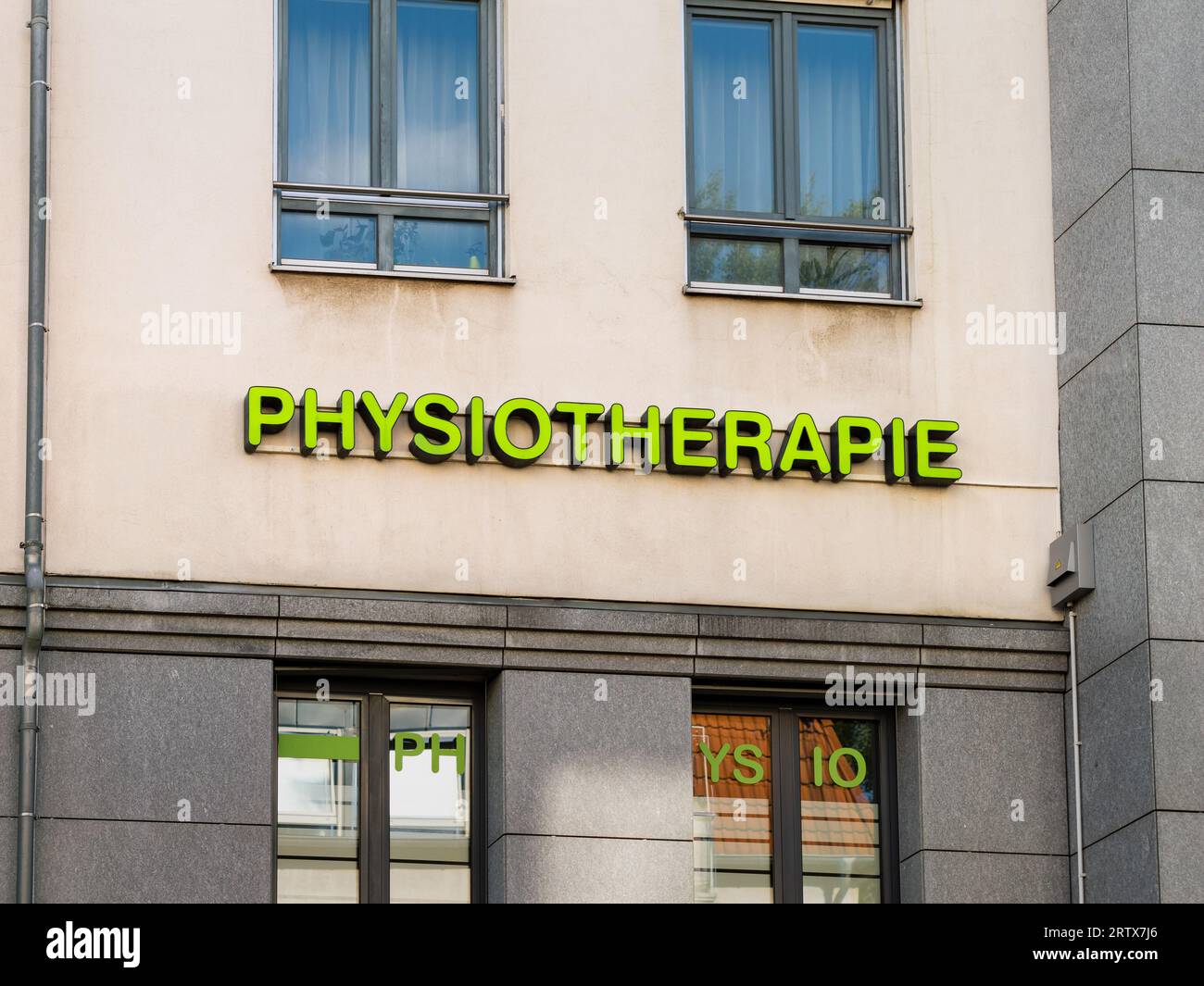 Scritta Physiotherapie (fisioterapia) sulla facciata di un edificio. L'annuncio mostra dove si trova la pratica fisioterapica. Foto Stock