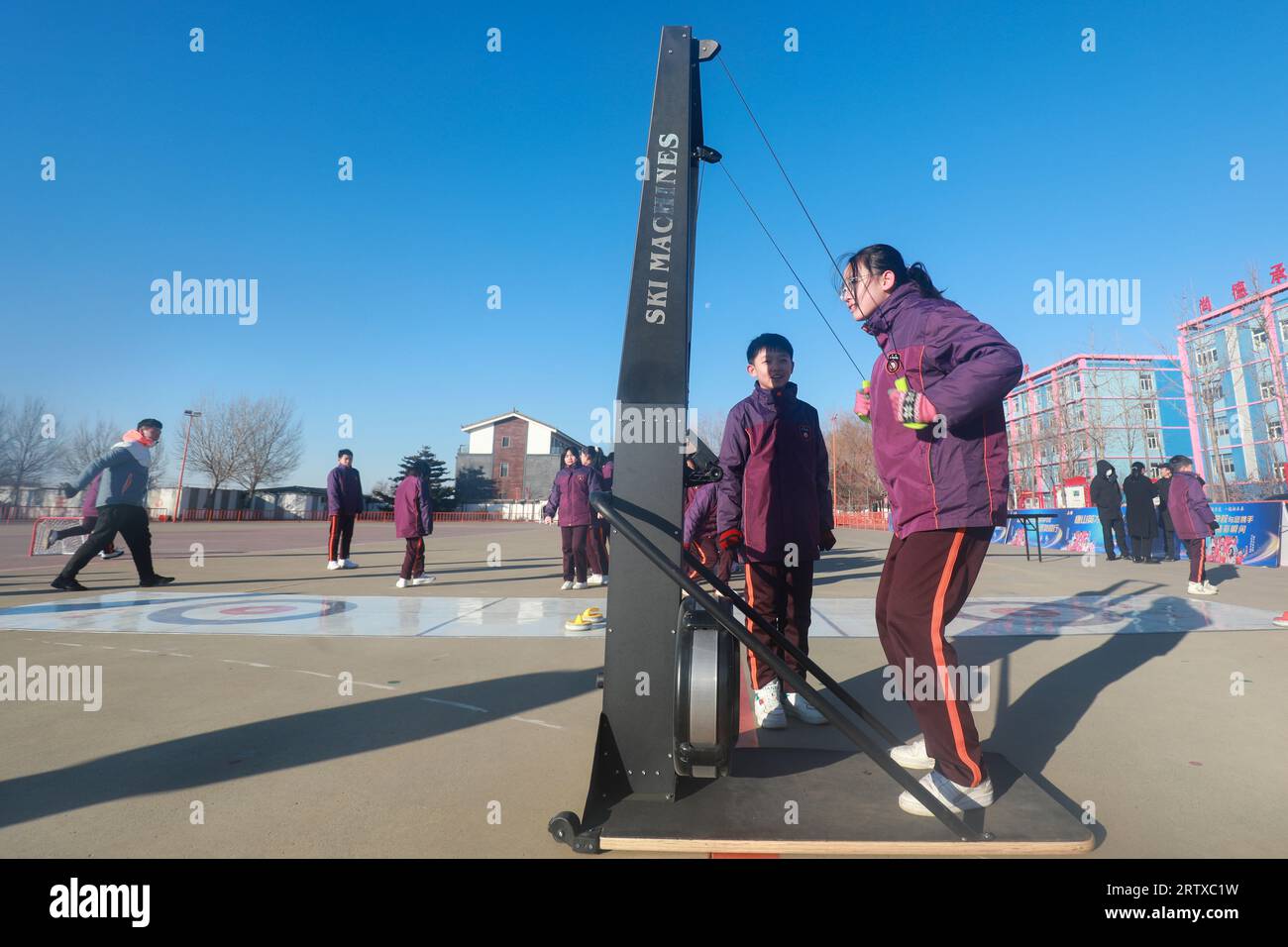 CONTEA DI LUANNAN, Cina - 24 dicembre 2021: Gli studenti stanno sperimentando la resistenza al vento per simulare uno sci sul parco giochi, nel nord della Cina. Foto Stock