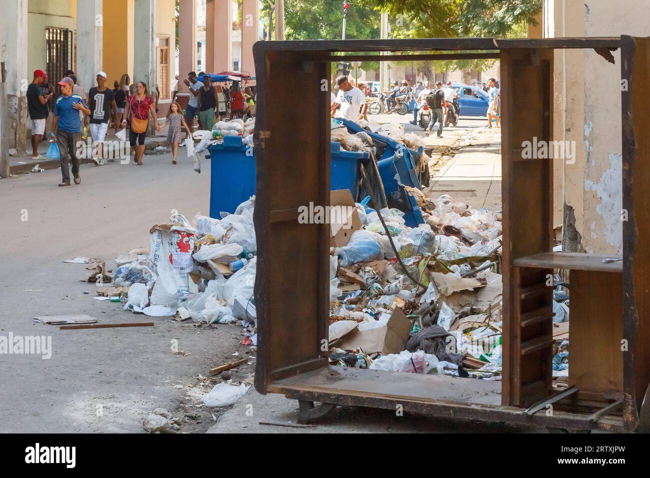 Havana, Cuba, 2023, cubani che camminano in una strada cittadina dove si trova un grande discarica Foto Stock
