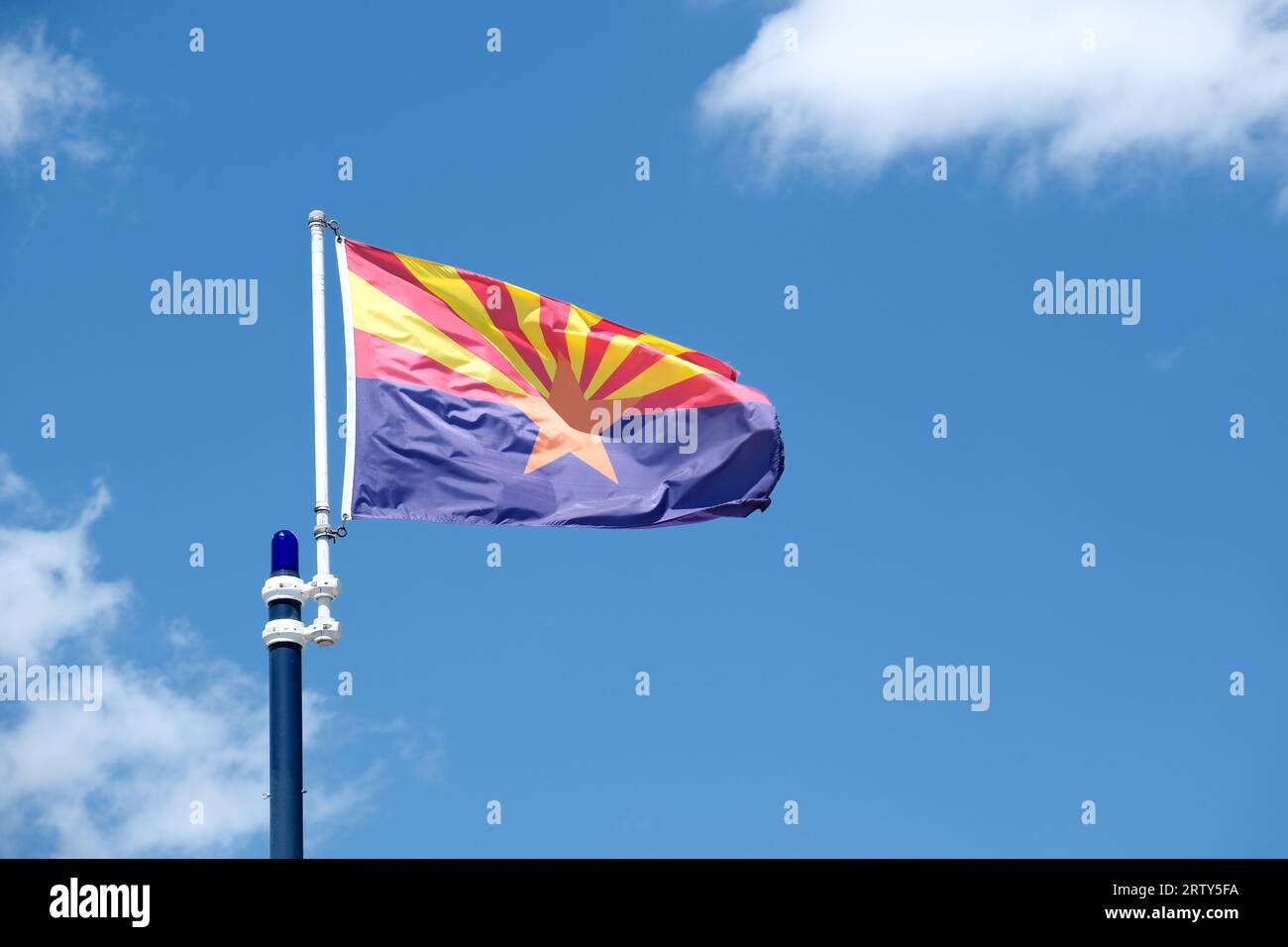 Primo piano della bandiera dello stato dell'Arizona sullo sfondo del cielo blu e delle nuvole bianche Foto Stock