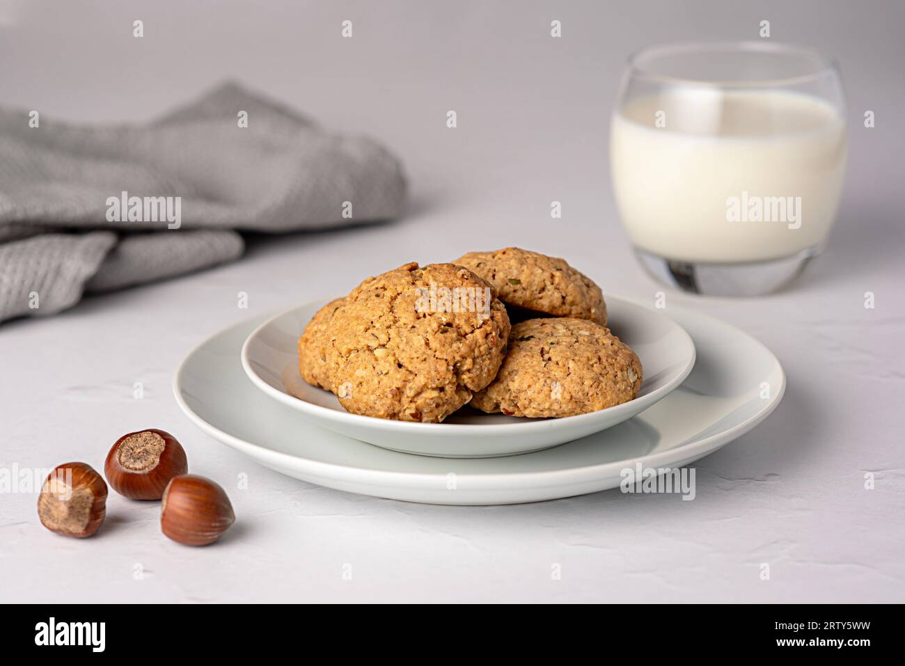 Fotografia alimentare di biscotti d'avena; farina d'avena; biscotti;noci; nocciole, pasticceria, latte, vetro, piatto Foto Stock