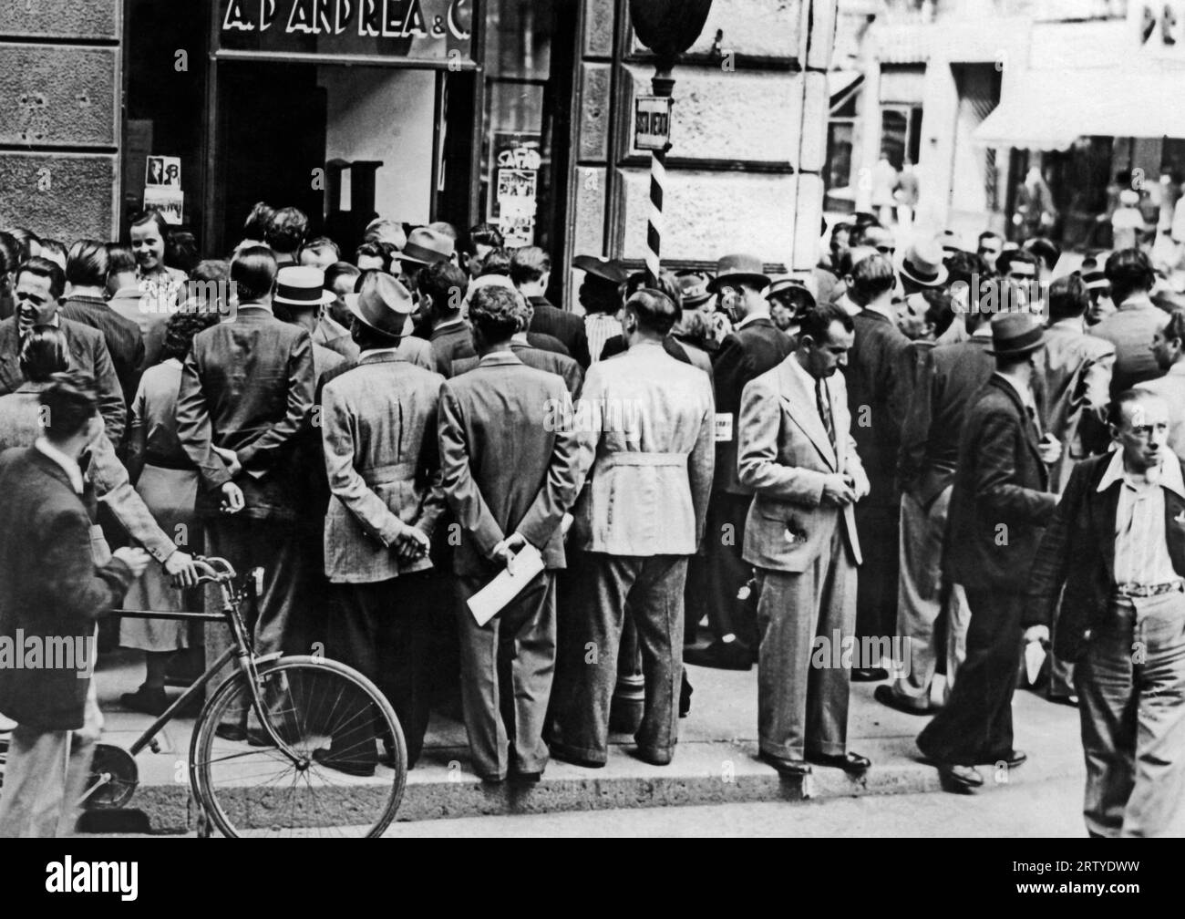 Milano, Italia c 1933 pedoni in strada si fermano per ascoltare una radio. Foto Stock