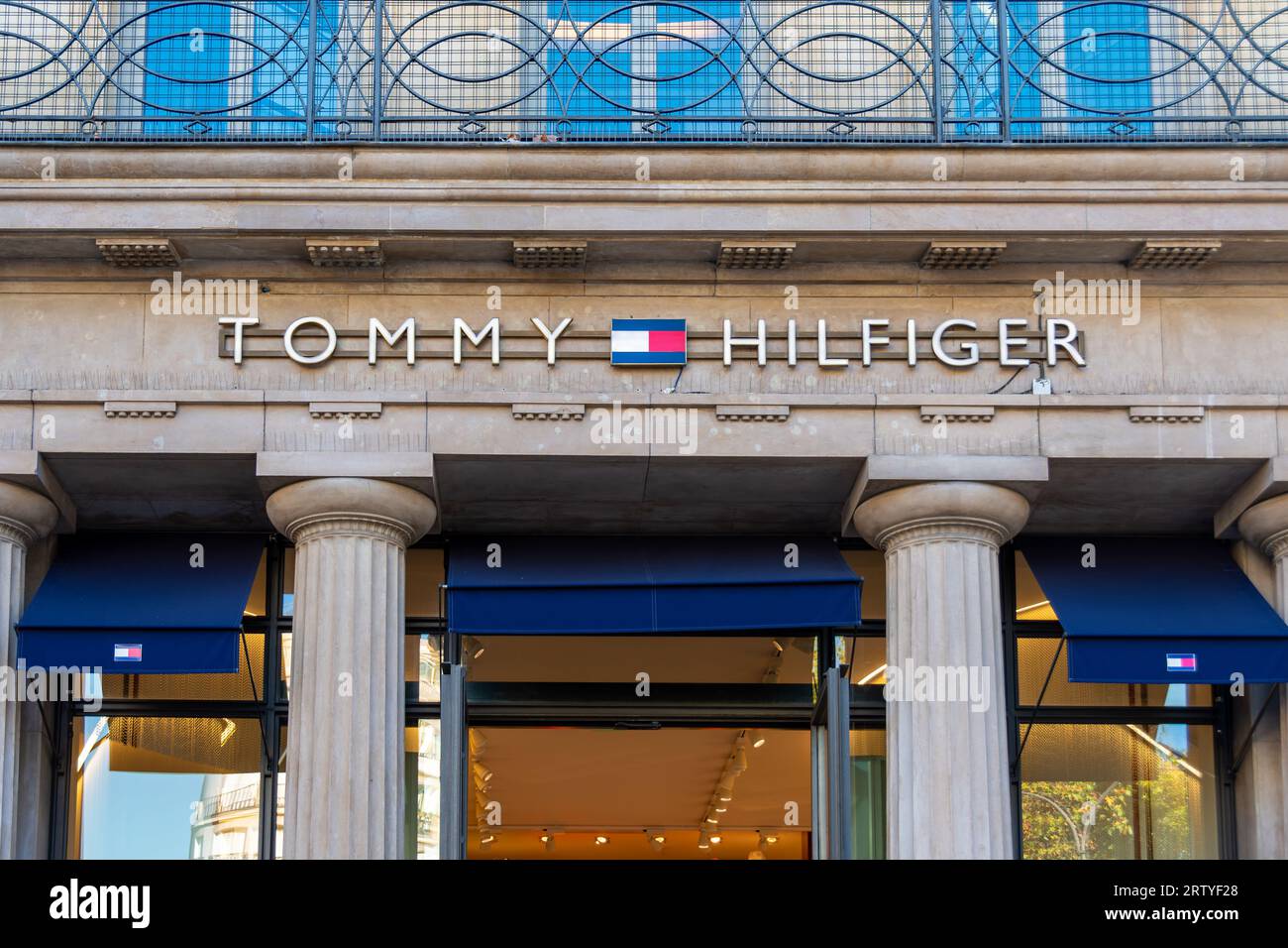 Insegna e logo all'ingresso del flagship store parigino di Tommy Hilfiger, un marchio di abbigliamento fondato dal designer americano Tommy Hilfiger Foto Stock