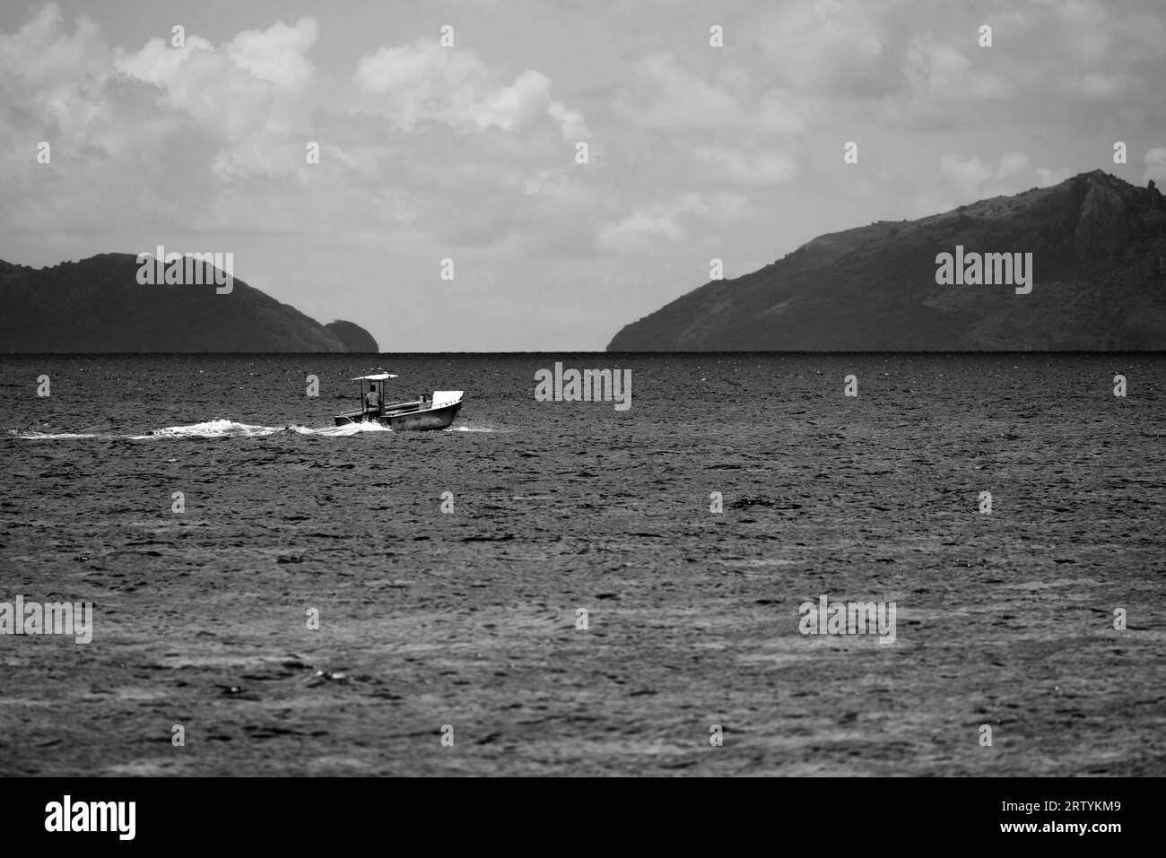 barca monocromatica che attraversa l'oceano delle figi Foto Stock