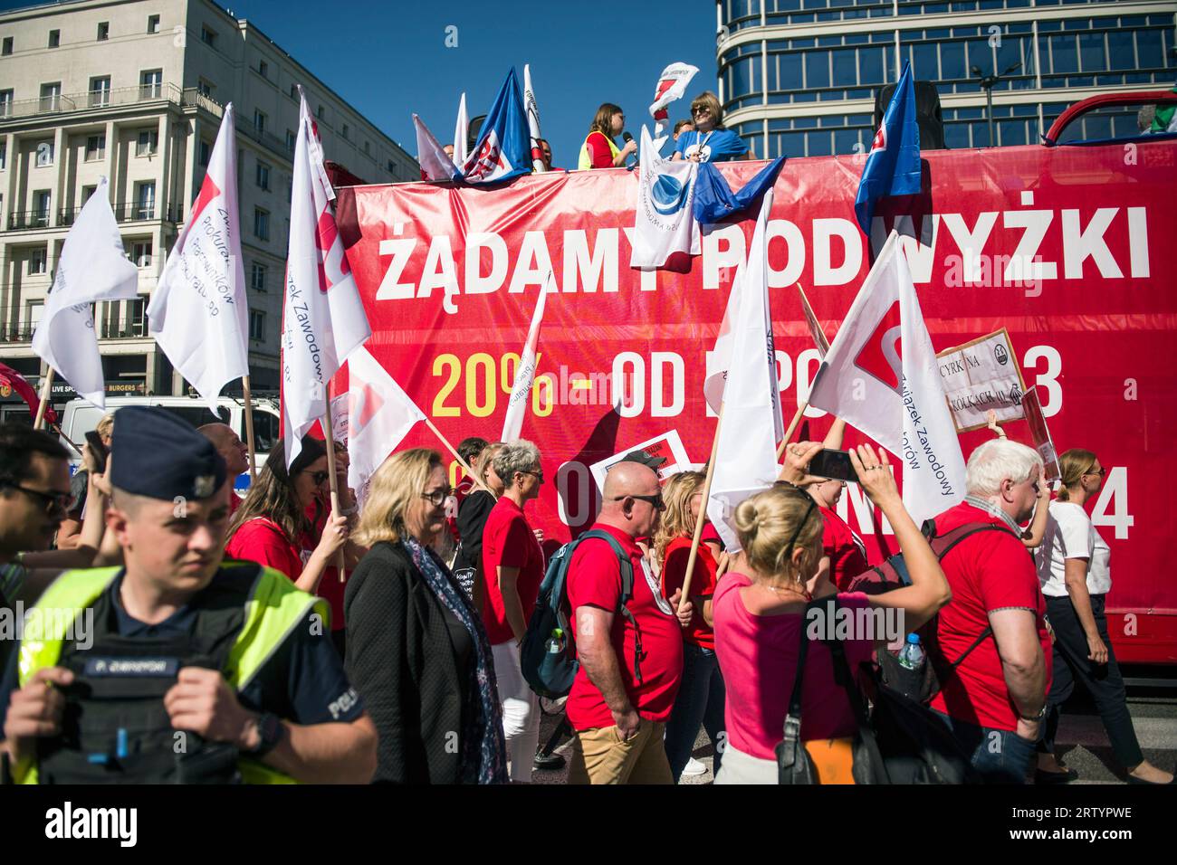 I manifestanti tengono cartelli e sventolano bandiere sindacali durante la "marcia della rabbia" a Varsavia. Migliaia di dipendenti del settore pubblico - sotto lo slogan "marcia della rabbia" (Marsz Gniewu) - hanno marciato per le strade di Varsavia per protestare contro i bassi salari. La sua causa diretta è la mancata attuazione delle richieste dei dipendenti di bilancio. I sindacati dei dipendenti del bilancio hanno chiesto l'indicizzazione dell'aumento medio annuo dello stipendio del 20 per cento. Dal 1° luglio 2023 e il 24% dal 1° gennaio 2024. E questa protesta, un mese prima delle elezioni parlamentari, è stata organizzata dall'Alleanza polacca di T Foto Stock