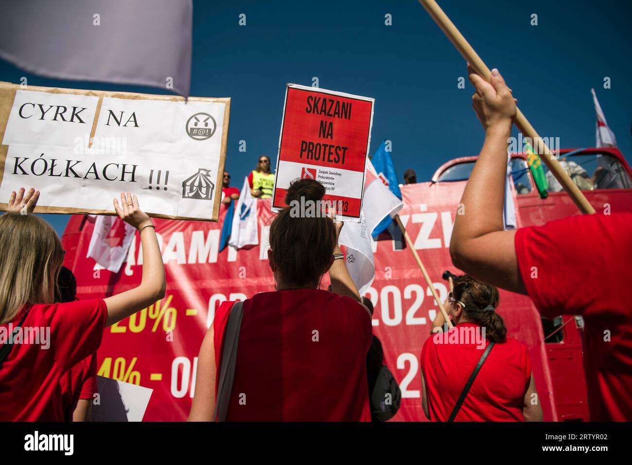 Un manifestante detiene un cartello che dice "condannato a protestare” durante la "marcia della rabbia” a Varsavia. Migliaia di dipendenti del settore pubblico - sotto lo slogan "marcia della rabbia" (Marsz Gniewu) - hanno marciato per le strade di Varsavia per protestare contro i bassi salari. La sua causa diretta è la mancata attuazione delle richieste dei dipendenti di bilancio. I sindacati dei dipendenti del bilancio hanno chiesto l'indicizzazione dell'aumento medio annuo dello stipendio del 20 per cento. Dal 1° luglio 2023 e il 24% dal 1° gennaio 2024. E questa protesta, un mese prima delle elezioni parlamentari, è stata organizzata dall'Allia tutta polacca Foto Stock