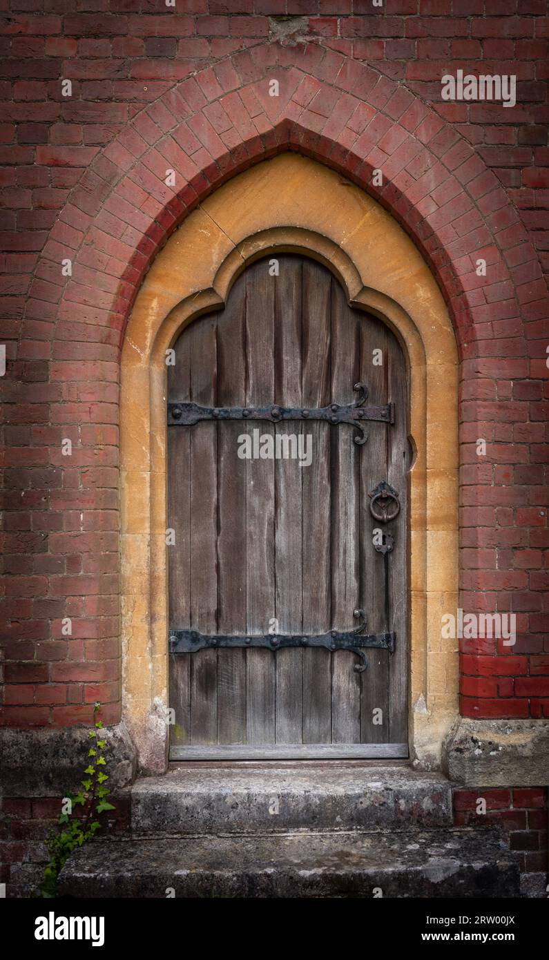 Un'antica porta d'ingresso rustica in legno per una chiesa, Inghilterra, Regno Unito Foto Stock