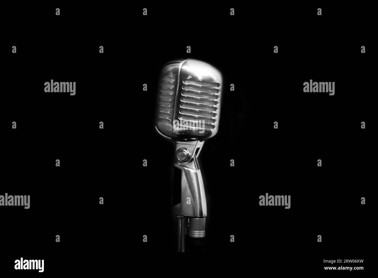 Attrezzatura professionale strumento di canto retrò, microfono argento su sfondo nero scuro. Foto Stock