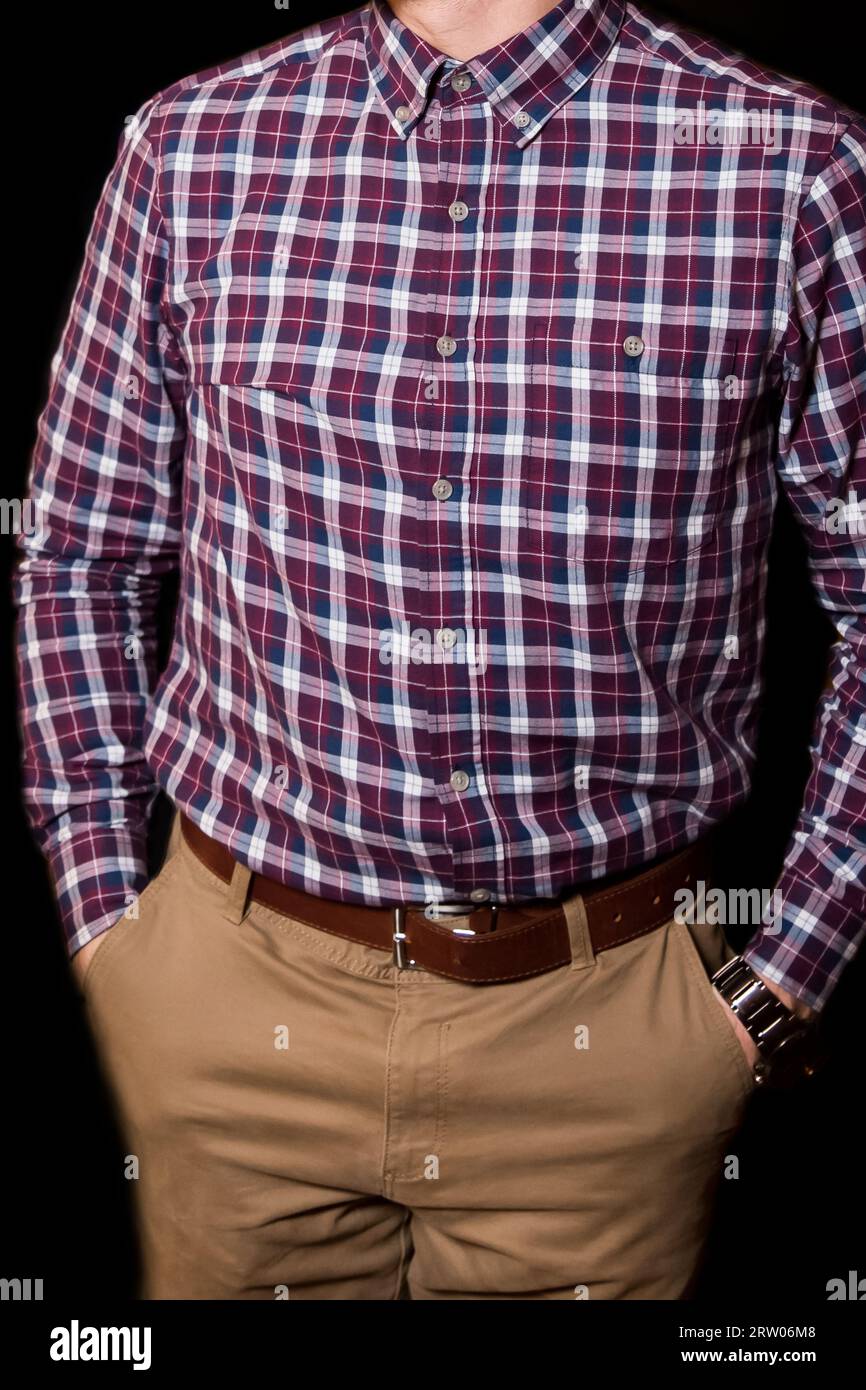 Stile cerimoniale da uomo con camicia in stile Bordeaux a quadri e pantaloni color senape su sfondo scuro. Foto Stock