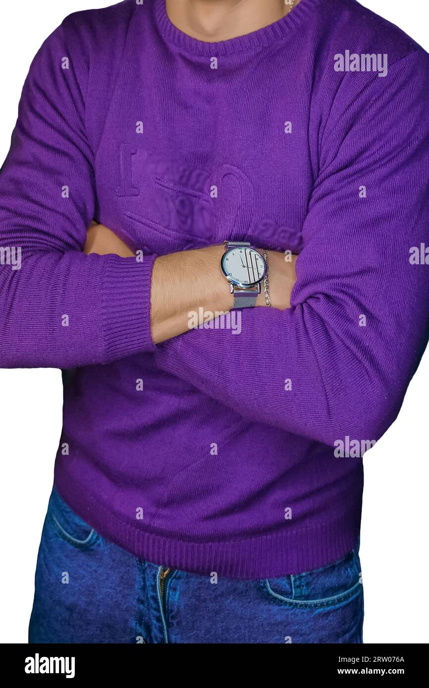 Uomo in posa con un orologio da polso con un maglione viola, moda e stile di abbigliamento su uno sfondo bianco isolato. Foto Stock